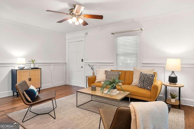 living room with hardwood / wood-style flooring, ornamental molding, and ceiling fan