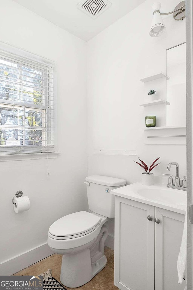 bathroom featuring tile patterned flooring, toilet, and vanity