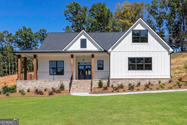 modern farmhouse featuring a porch, a front yard, and french doors