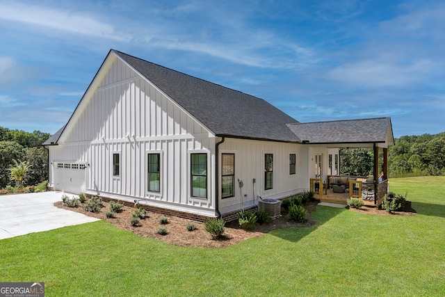 view of home's exterior featuring a lawn, cooling unit, and a garage