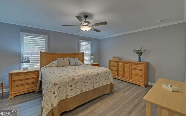 bedroom with wood-type flooring, ornamental molding, and ceiling fan