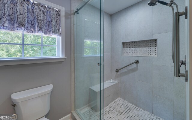 bathroom featuring walk in shower and toilet