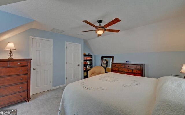 carpeted bedroom with ceiling fan, a textured ceiling, and lofted ceiling