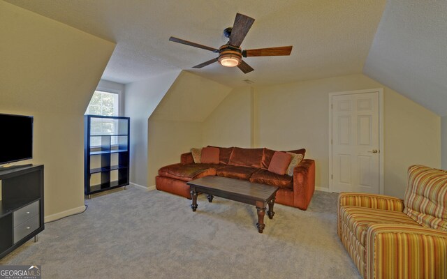 carpeted living room featuring ceiling fan, a textured ceiling, and lofted ceiling