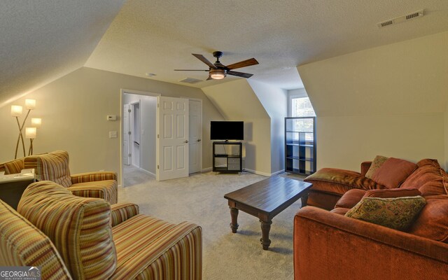 carpeted living room featuring vaulted ceiling, ceiling fan, and a textured ceiling