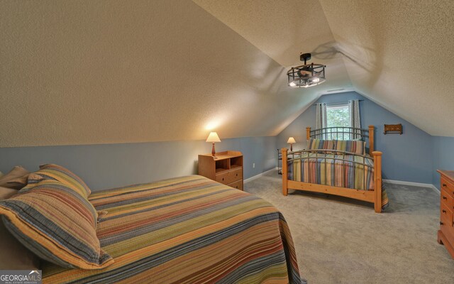 bedroom with carpet flooring, vaulted ceiling, and a textured ceiling