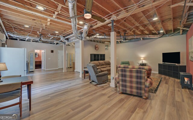 basement with white refrigerator and hardwood / wood-style floors