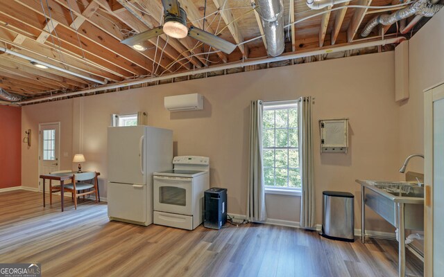 kitchen with a wall unit AC, ceiling fan, white appliances, and wood-type flooring