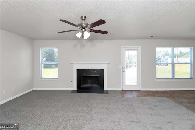 unfurnished living room featuring carpet flooring, a textured ceiling, and ceiling fan