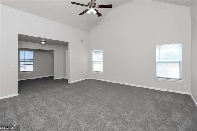 spare room with dark colored carpet, ceiling fan, and high vaulted ceiling