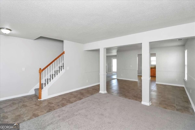 basement with dark carpet and a textured ceiling