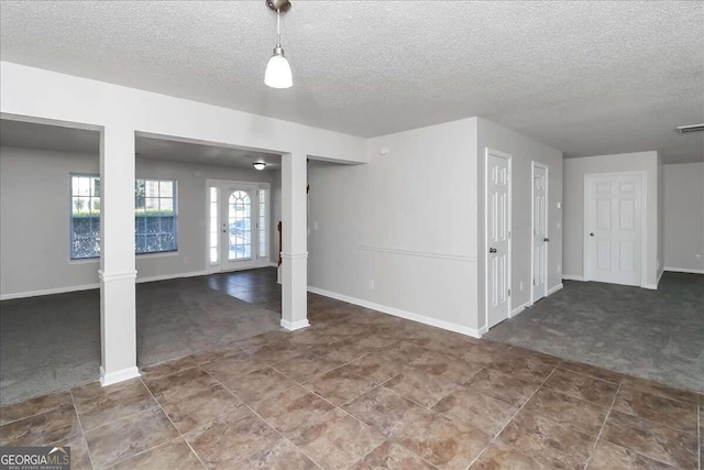 basement with french doors, carpet floors, and a textured ceiling