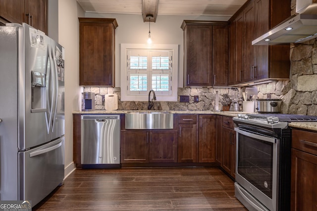 kitchen with hanging light fixtures, decorative backsplash, beam ceiling, stainless steel appliances, and extractor fan