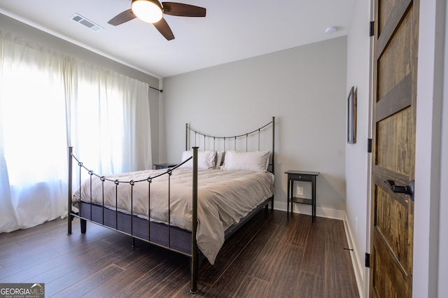 bedroom with dark hardwood / wood-style floors and ceiling fan