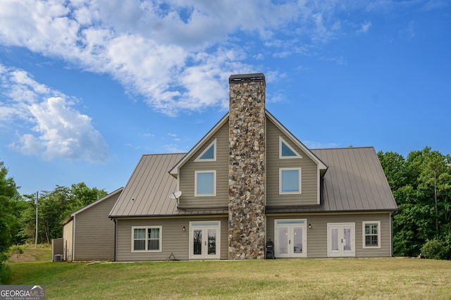 rear view of house with a lawn and french doors