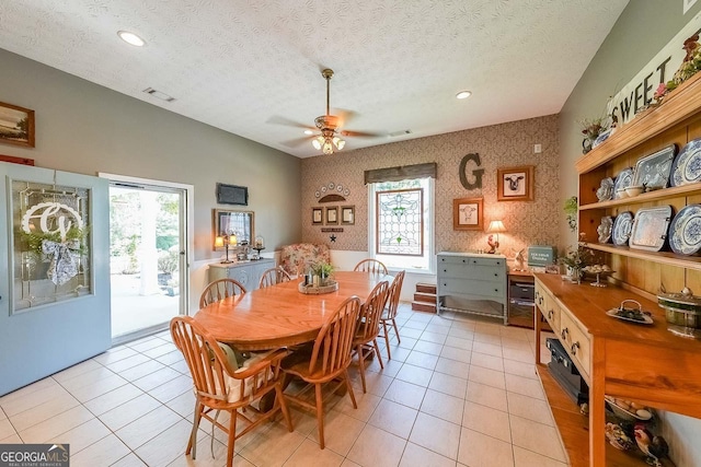 dining room with a textured ceiling, ceiling fan, and light tile patterned flooring