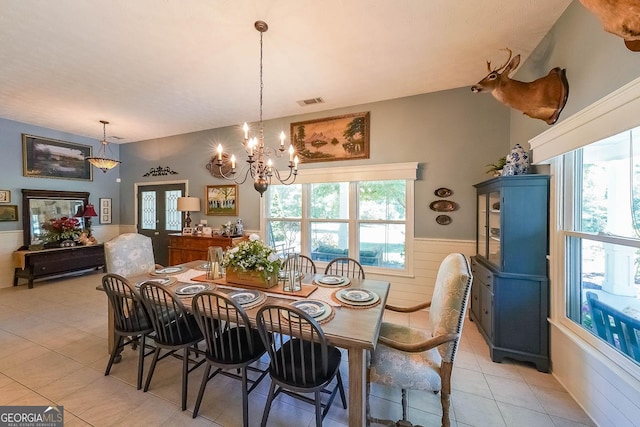 dining area featuring light tile patterned floors and a notable chandelier