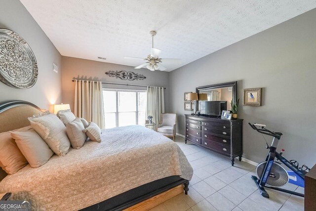 tiled bedroom with a textured ceiling and ceiling fan