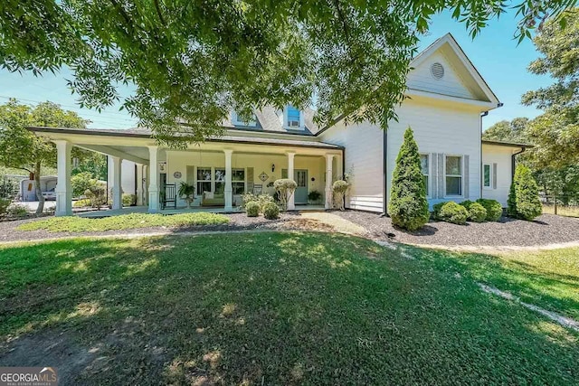 back of house featuring a yard and covered porch