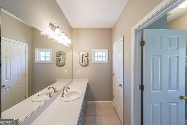 bathroom featuring tile patterned floors, vanity, a healthy amount of sunlight, and a textured ceiling