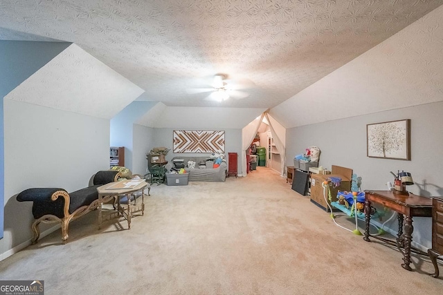 playroom featuring carpet flooring, ceiling fan, vaulted ceiling, and a textured ceiling