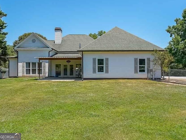 rear view of property featuring a yard and a patio