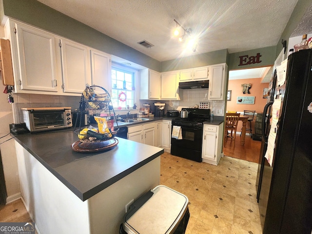 kitchen with decorative backsplash, kitchen peninsula, white cabinets, and black appliances