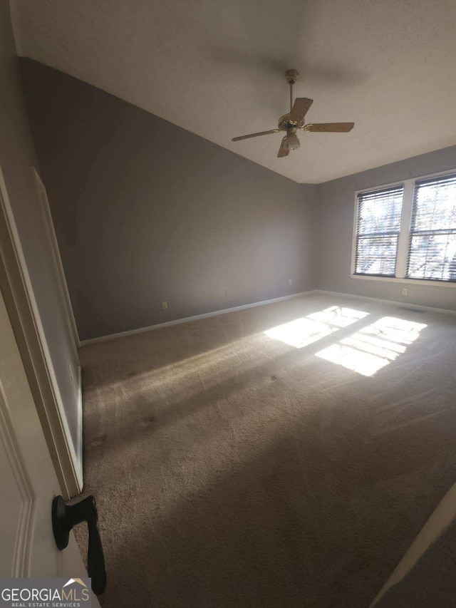 spare room with carpet floors, vaulted ceiling, and ceiling fan