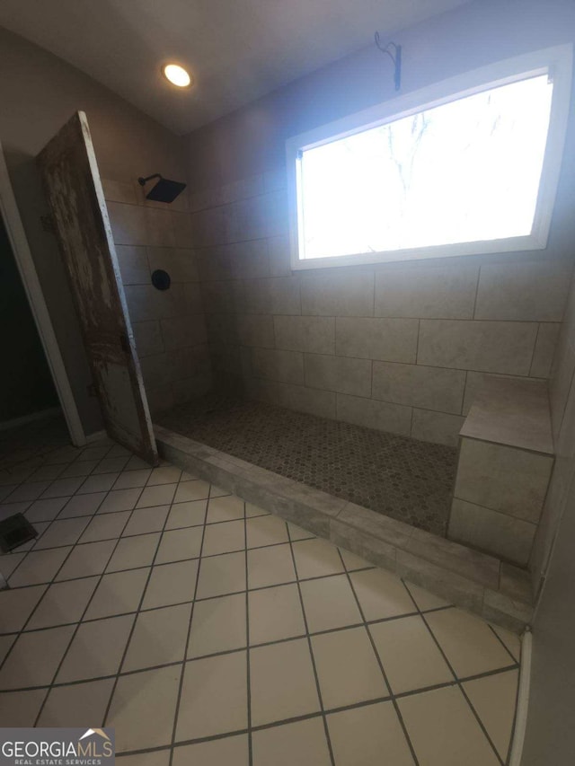 bathroom featuring tile patterned flooring and a tile shower