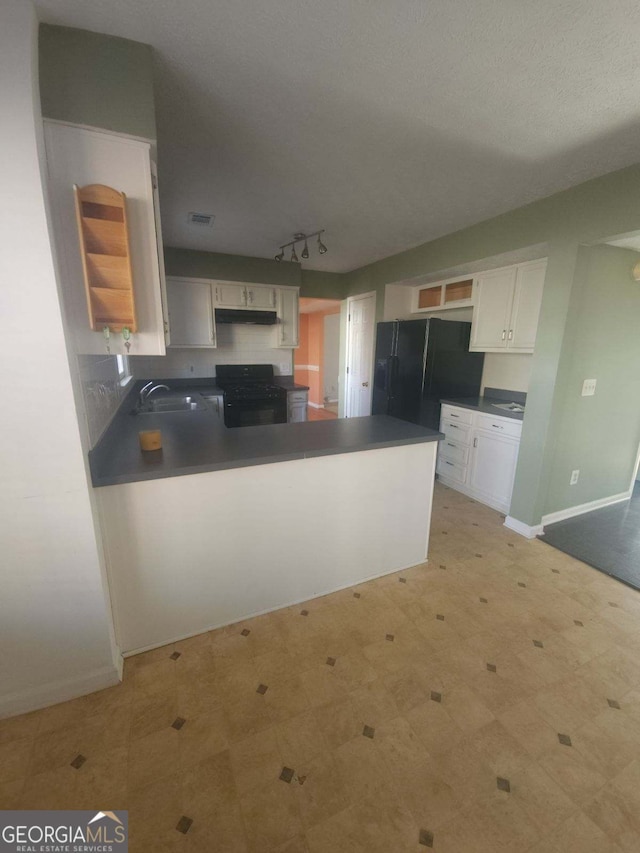 kitchen featuring white cabinetry, kitchen peninsula, sink, and black appliances