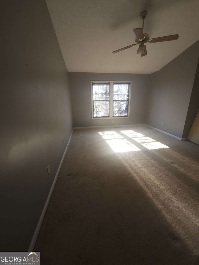 spare room featuring lofted ceiling, ceiling fan, and carpet