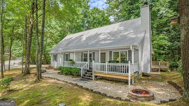 new england style home with a porch and an outdoor fire pit