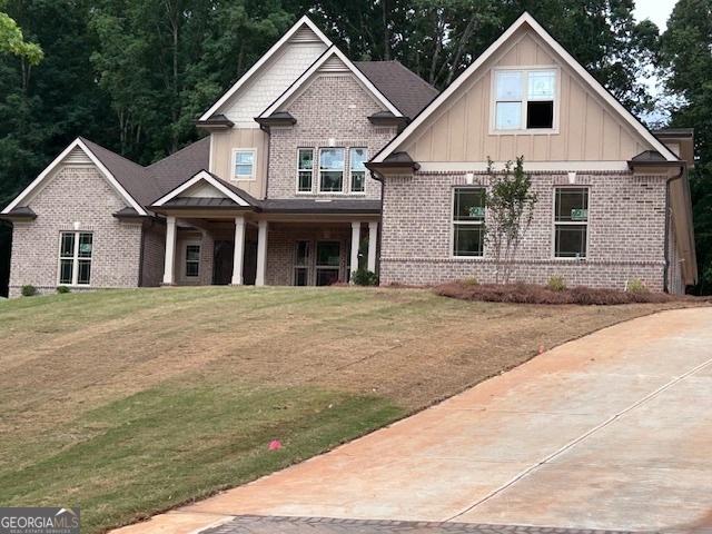 4563 Fawn Path, Gainesville, GA 30506 - craftsman house with brick siding, board and batten siding, a front yard, and a porch