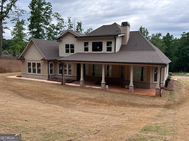 4563 Fawn Path, Gainesville, GA 30506 - view of front of house featuring a chimney, board and batten siding, a porch, and roof with shingles