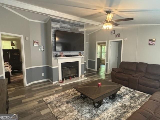 living room with crown molding, hardwood / wood-style flooring, a tile fireplace, ceiling fan, and vaulted ceiling