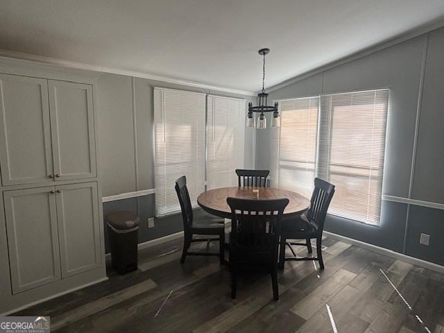 dining room with a healthy amount of sunlight, lofted ceiling, dark hardwood / wood-style flooring, and a notable chandelier