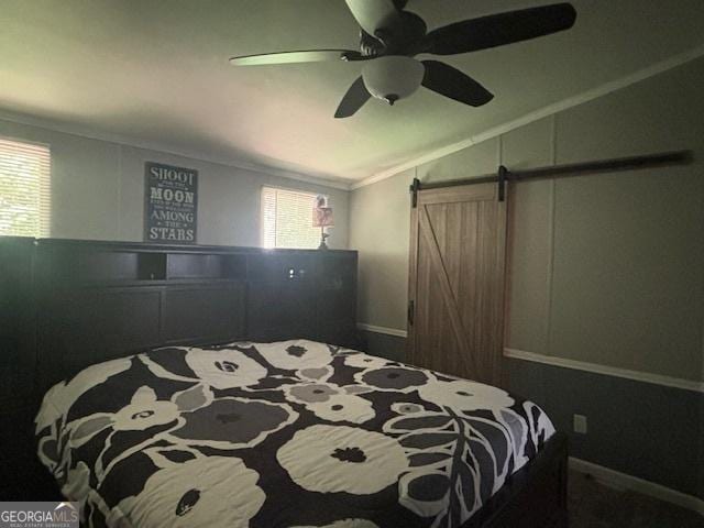 bedroom featuring crown molding, vaulted ceiling, a barn door, and ceiling fan