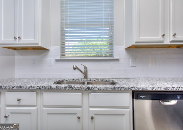 kitchen with white cabinets, dishwasher, light stone countertops, and sink