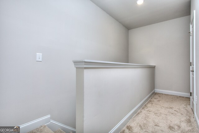 corridor with light carpet and lofted ceiling