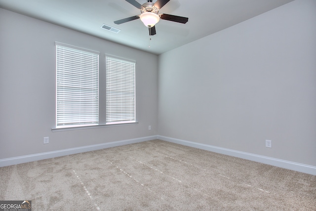 carpeted spare room featuring ceiling fan and a wealth of natural light