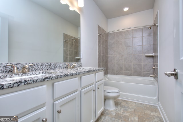 full bathroom featuring tiled shower / bath combo, vanity, and toilet