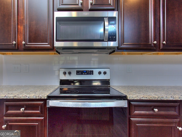 kitchen featuring light stone counters, stainless steel appliances, and tasteful backsplash