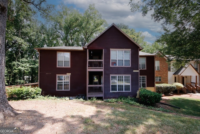 view of front of property featuring a balcony and a front lawn