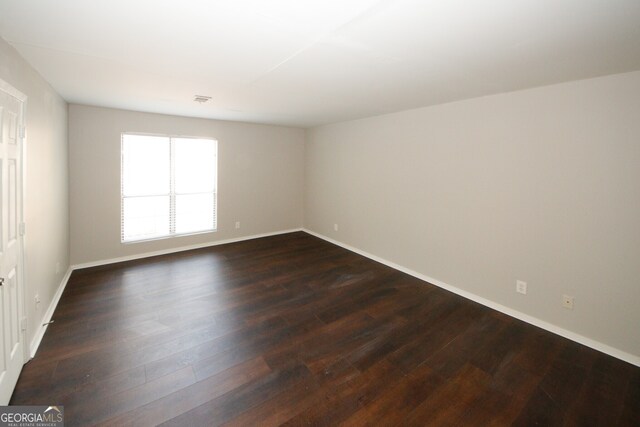 empty room with dark hardwood / wood-style flooring