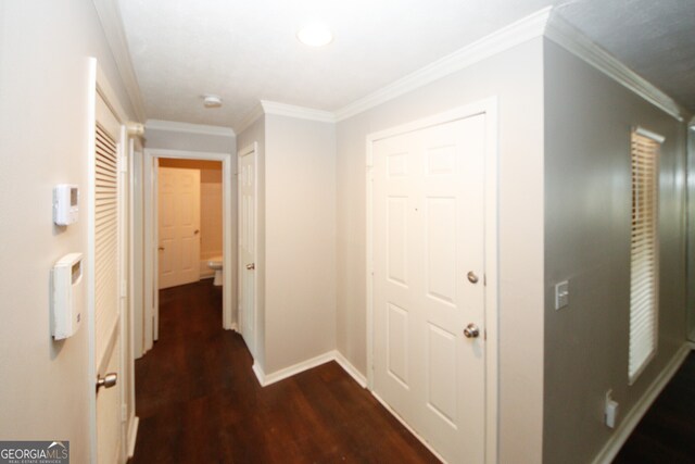 corridor featuring dark wood-type flooring and crown molding