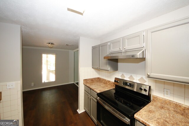 kitchen featuring dark hardwood / wood-style floors, decorative backsplash, gray cabinetry, crown molding, and stainless steel electric range