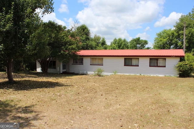 back of property with a lawn