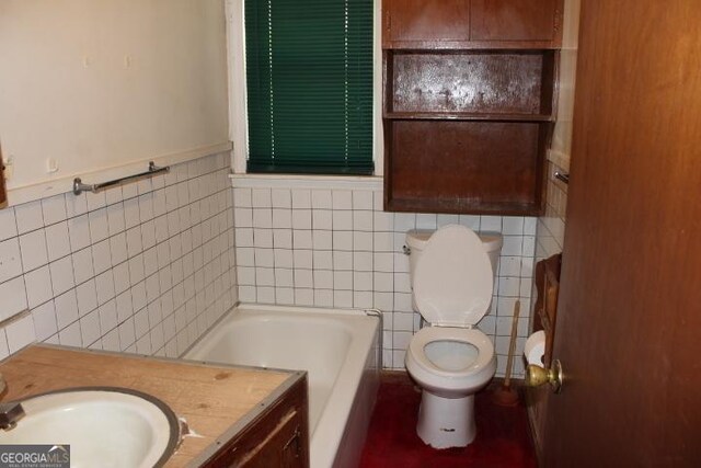 bathroom featuring tile walls, a bath, vanity, and toilet