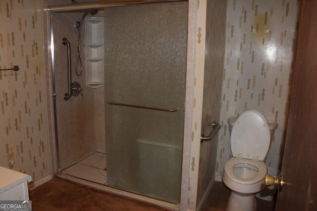 bathroom featuring tile flooring, an enclosed shower, vanity, and toilet