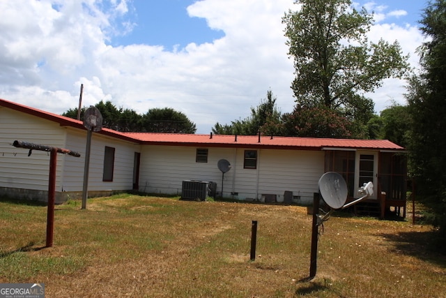 back of house with central AC and a yard